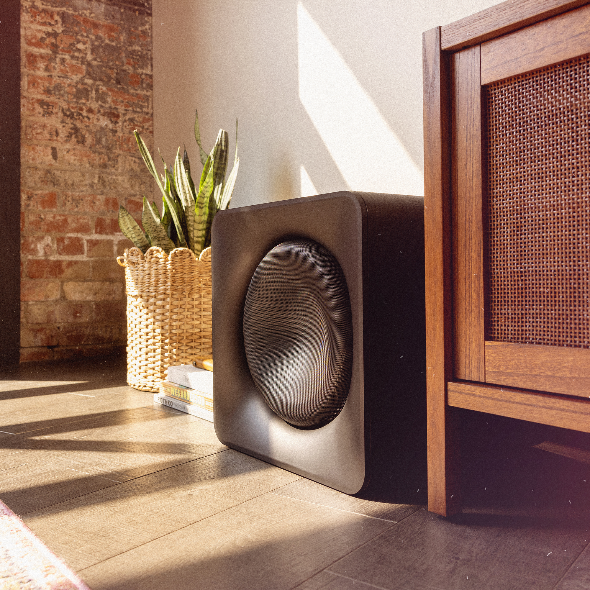 Klipsch Flexus SUB 200 in sunny living room beside snake plant in basket and media console 2000x2000