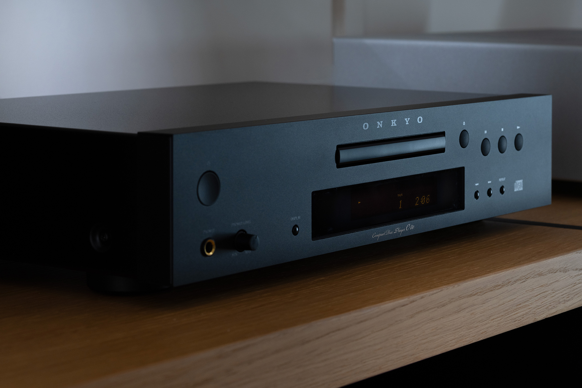 Onkyo C 30 CD Player angled closeup on wood shelf in moody light 2000x1333