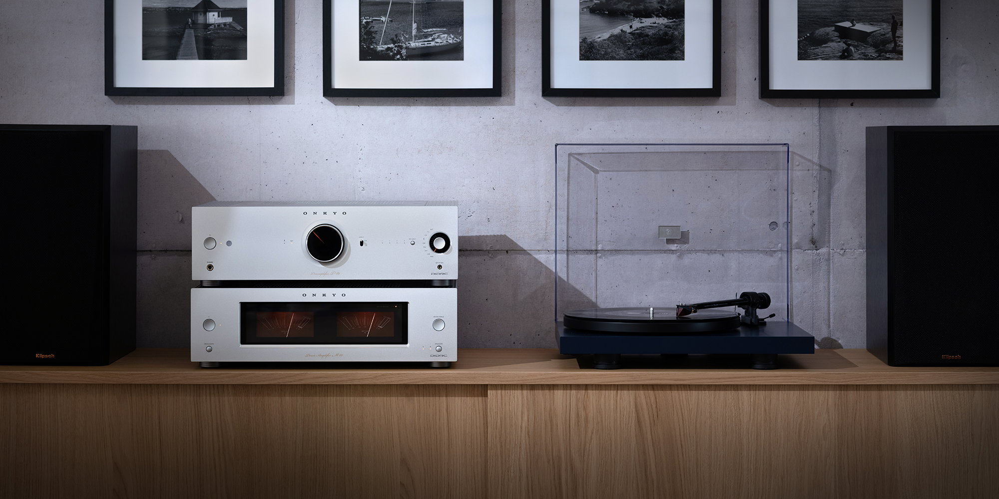 Onkyo Icon P 80 M 80 and turntable straight on between Klipsch bookshelf speakers on simple wood media console 2000x1000