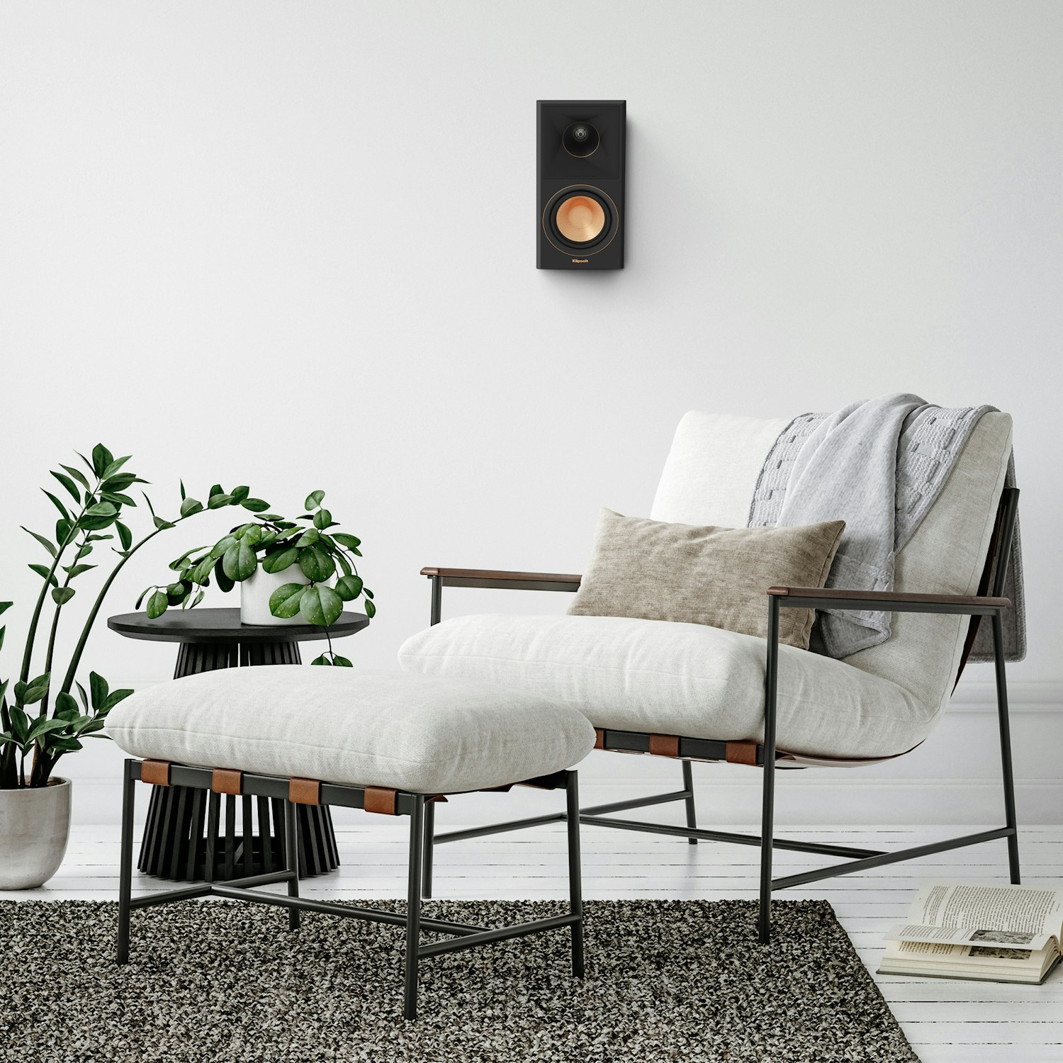 RP 500 SA II surround speaker hung on a greyish white wall near a chair mobile