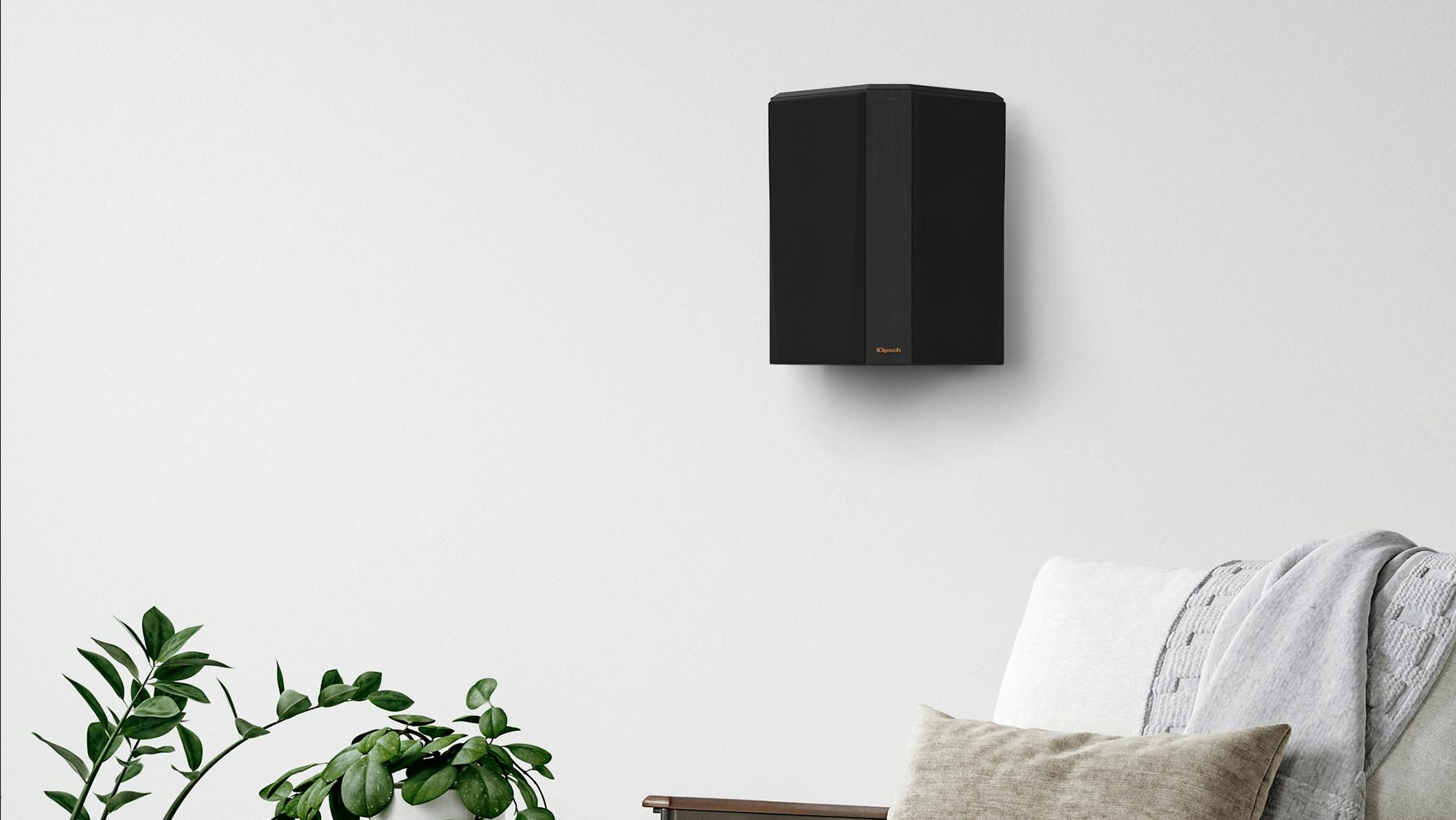 RP 502 S II surround speaker in black finish hung on a greyish wall
