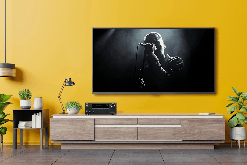 TX NR696 Playing Concert in Living Room with Yellow Wall 2000x1333