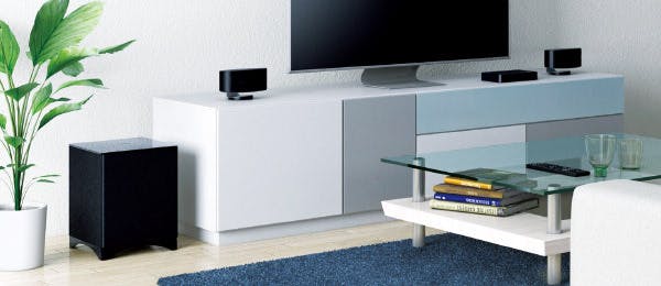 LS-3100 home audio system in a living room with white furniture and a blue carpet